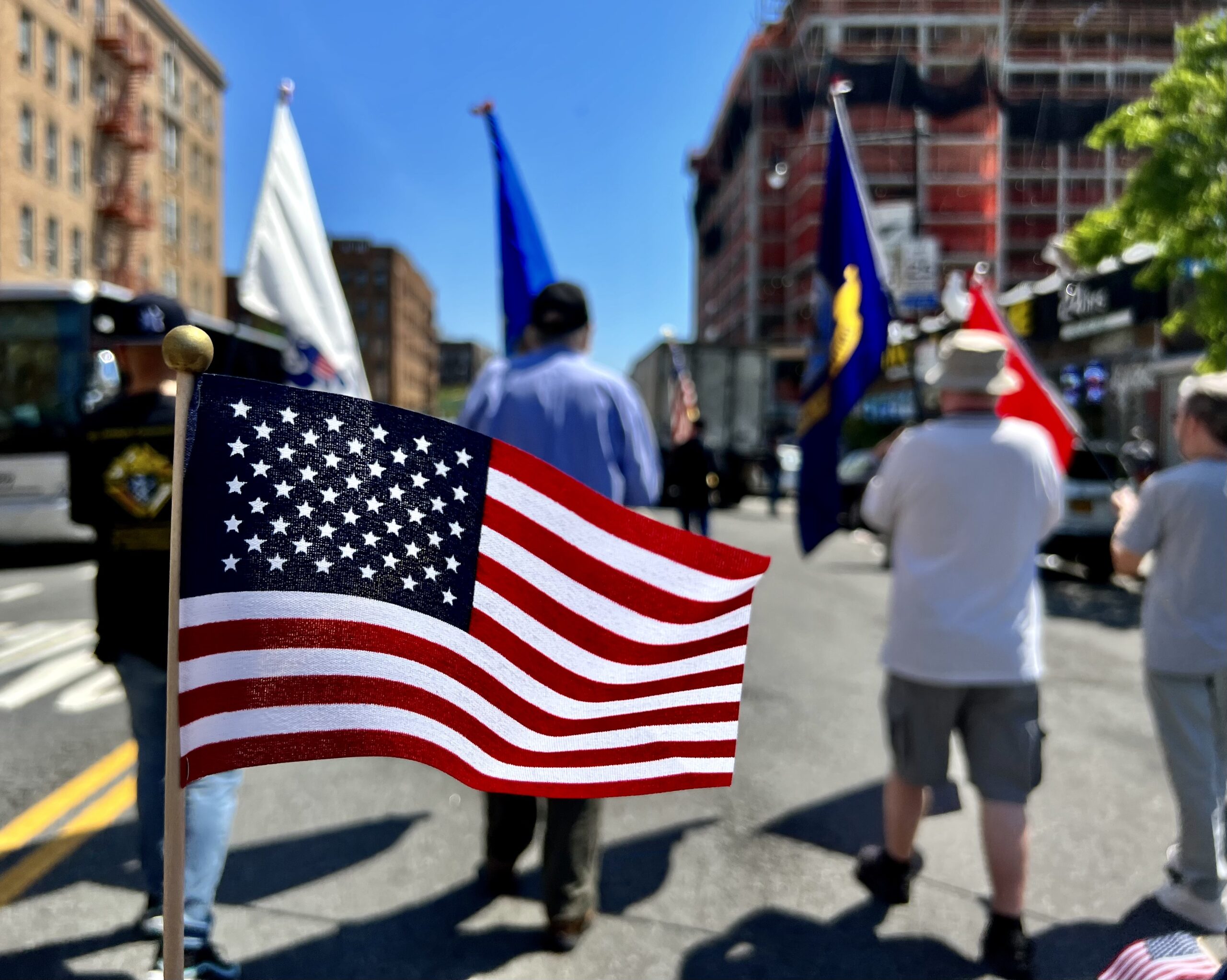 American Flag with other military flag during a parade.
