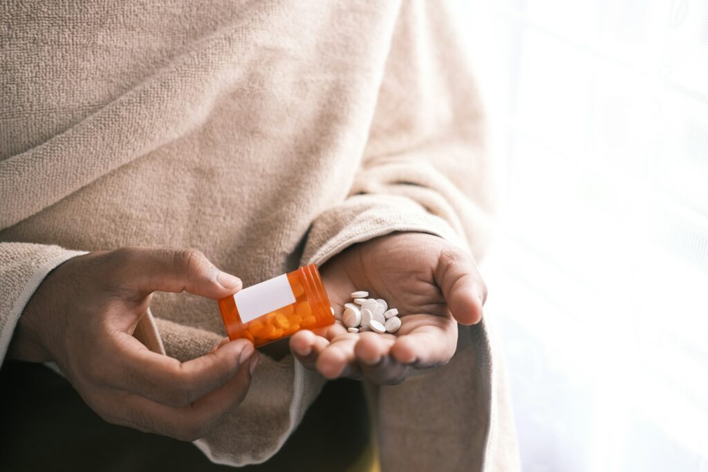Opioid crisis, pills, bottle and hand